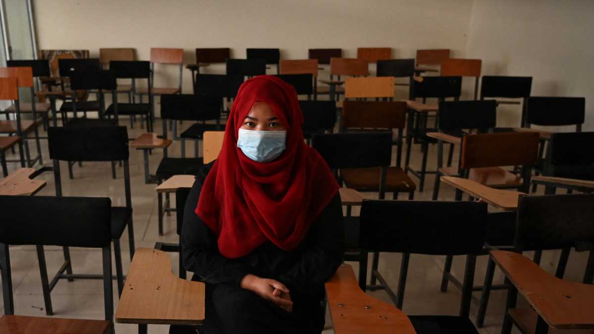 Un estudiante se sienta dentro de un aula después de que las universidades privadas reabrieran en Kabul el 6 de septiembre de 2021. - Las mujeres que asisten a universidades privadas afganas deben usar una bata abaya y un niqab que cubra la mayor parte de la cara, han ordenado los talibanes, y las clases deben estar segregadas por sexo - - o al menos dividido por una cortina. (Foto de Aamir QURESHI / AFP)