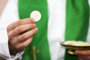 Sacerdote de la comunión en la mano