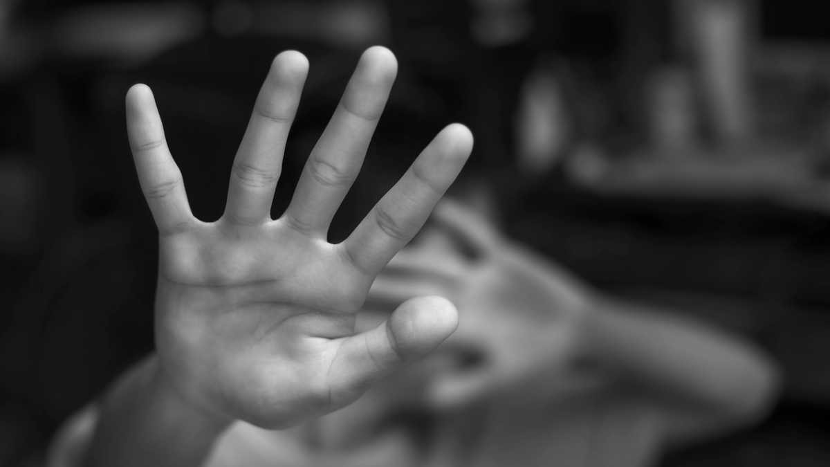 Muchacho que muestra el gesto de PARADA con la mano. Concepto de violencia doméstica y abuso infantil.