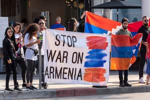 Manifestantes contra la escalada del conflicto entre Armenia y el vecino Azerbaiyán sostienen carteles y banderas a lo largo de la ruta de la caravana del presidente Trump hacia un evento para recaudar fondos en Newport Beach, California, el domingo 18 de octubre de 2020. Foto: Leorard Ortiz / The Orange County Register vía AP.