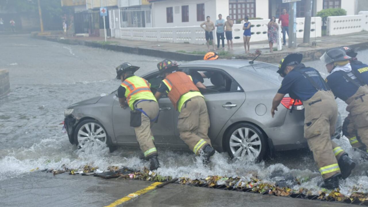 Cuerpo de Bomberos de Barranquilla rescatando un carro arrastrado por la corriente.