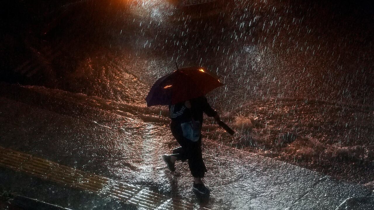 Una mujer sostiene un paraguas mientras camina bajo la lluvia en el distrito de Basaksehir de Estambul, Turquía, el martes 5 de septiembre de 2023.