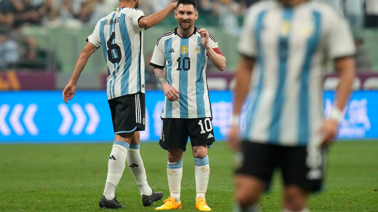 Argentina's Lionel Messi, center, and German Pezzela, left, reacts during during their friendly soccer match against Australia at the Workers' Stadium in Beijing, China, Thursday, June 15, 2023. (AP Photo/Andy Wong)