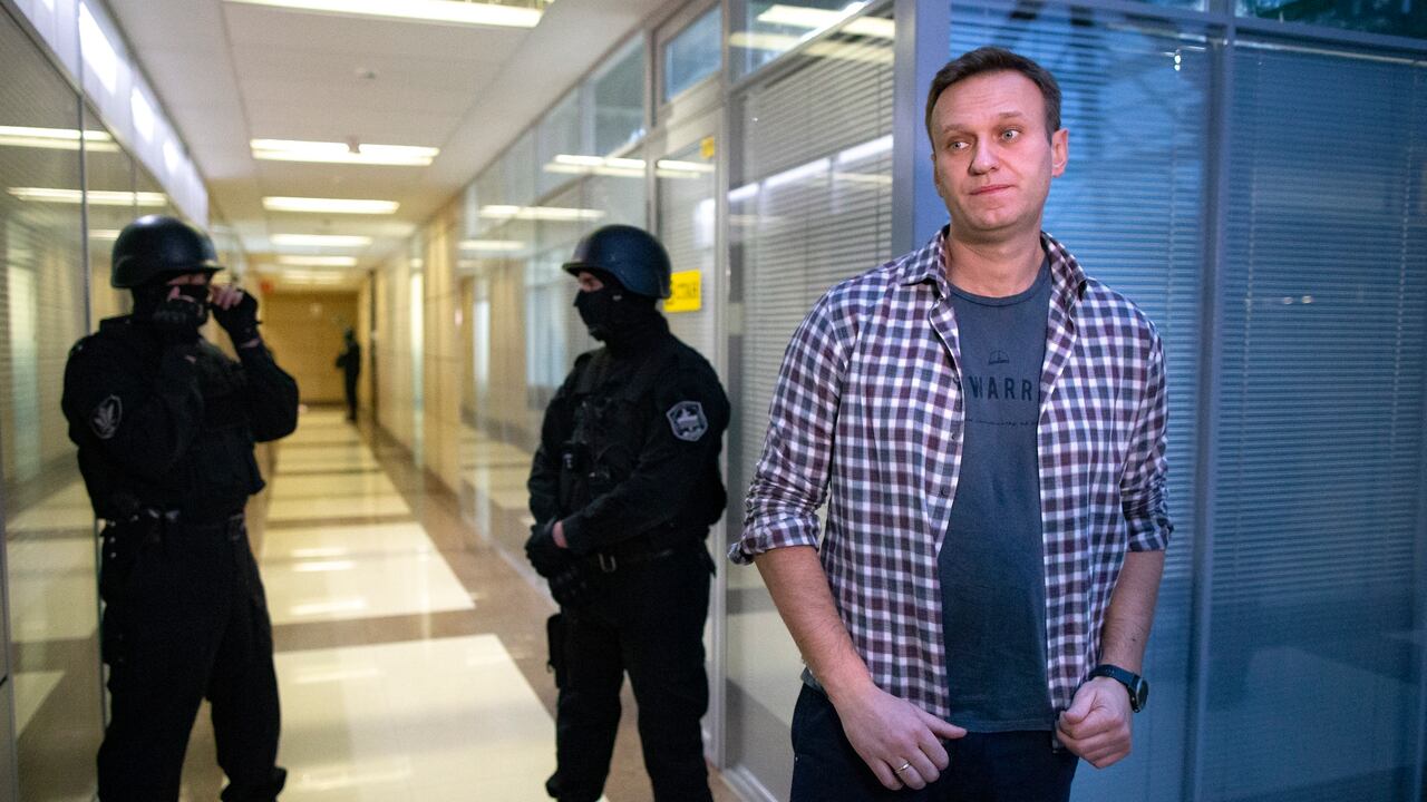 El líder de la oposición rusa Alexei Navalny habla con los medios frente a agentes de seguridad que hacen guardia