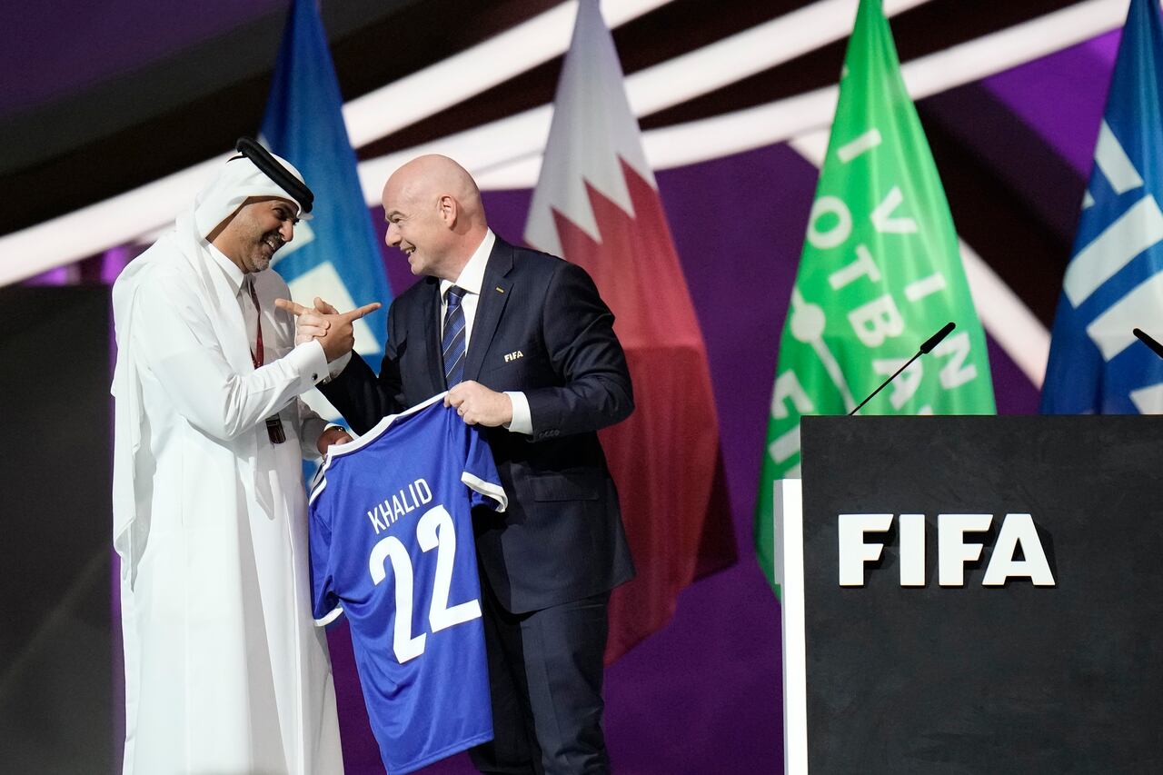 Prime Minister of the State of Qatar, Khalid Bin Khalifa Bin Abdulaziz Al Thani, left, receives a gift from FIFA President Gianni Infantino during the FIFA congress at the Doha Exhibition and Convention Center in Doha, Qatar, Thursday, March 31, 2022. (AP Photo/Hassan Ammar)