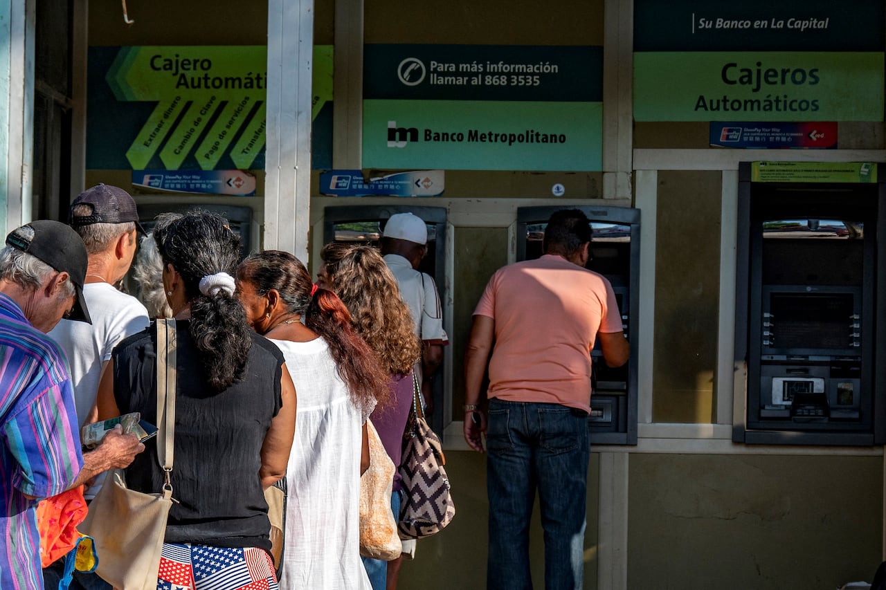 Varias personas hacen fila para retirar dinero de cajeros automáticos en un banco de La Habana el 3 de agosto de 2023.