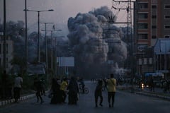 Los palestinos observan el humo que se eleva tras un ataque aéreo israelí en Deir al-Balah, en el centro de la Franja de Gaza,