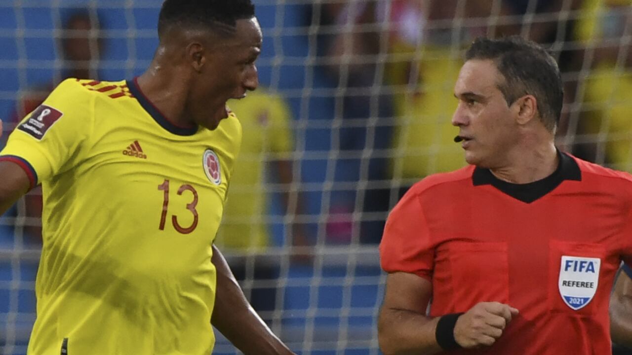 Argentine referee Patricio Loustau (R) speaks with Colombia's Yerry Mina during the South American qualification football match for the FIFA World Cup Qatar 2022 between Colombia and Brazil at the Metropolitano stadium in Barranquilla, Colombia, on October 10, 2021.
JUAN BARRETO / AFP