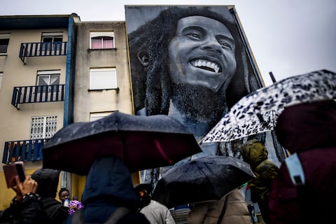 (FILES) In this file photo taken on November 17, 2019 Visitors watch a mural by Portuguese artist Odeith depicting Jamaican singer Bob Marley during a guided visit to Quinta do Mocho neighbourhood in Sacavem, outskirts of Lisbon. - It's been four decades since Bob Marley's death, a period longer than the reggae icon's brief but potent life that skin cancer ended when he was 36.