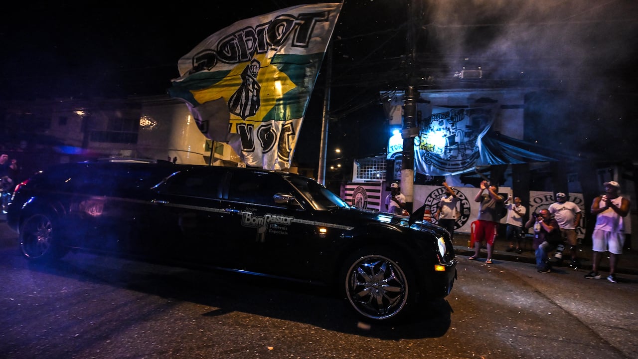 A hearse carrying the coffin of Brazilian football legend Pele arrives at Vila Belmiro stadium as fans mourn his death in Santos on January 2, 2023. - A 24-hour wake for Pele will be held at Vila Belmiro stadium in Santos starting January 2, following by what is expected to be a massive funeral procession through the city before his burial at Santos's Necropole Memorial Cemetery in a private ceremony on January 3. (Photo by NELSON ALMEIDA / AFP)