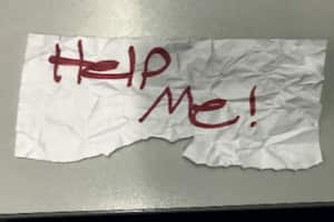 En esta fotografía sin fecha proporcionada por el Departamento de Justicia de Estados Unidos muestra un letrero con el mensaje "¡Ayúdenme!" utilizado por una niña de 13 años que fue secuestrada en Texas. (Departamento de Justicia de Estados Unidos vía AP)