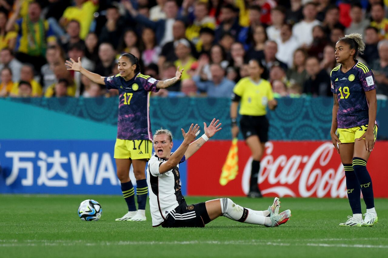 Germany's Alexandra Popp, on the ground, looks for a penalty call, between Colombia's Carolina Arias, left, and Jorelyn Carabali during the Women's World Cup Group H soccer match between Germany and Colombia at Sydney Football Stadium in Sydney, Australia, Friday, July 28, 2023. (AP Photo/Sophie Ralph)