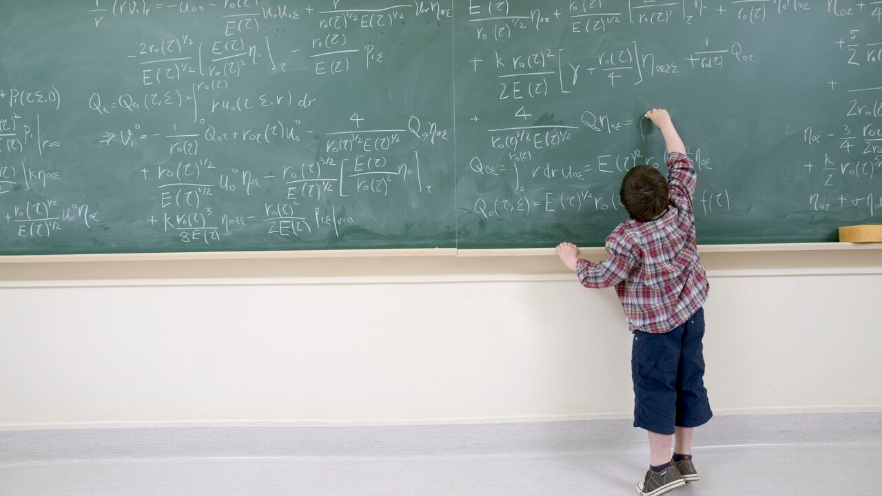Boy Working Out Complex Equation on Blackboard