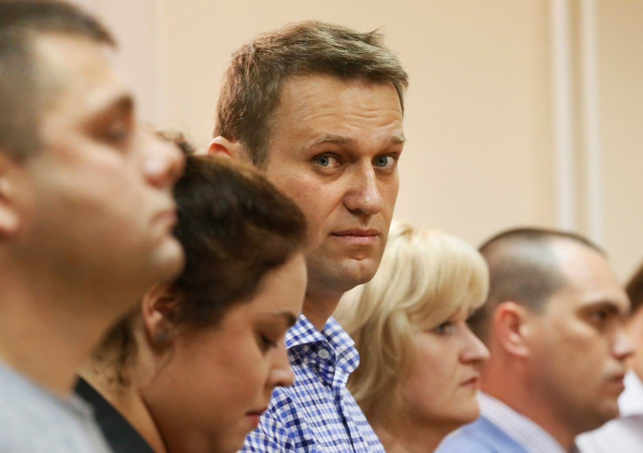 El líder de la oposición rusa Alexei Navalny, en el centro, y su ex colega Pyotr Ofitserov, en primer plano, escuchan al juez en un tribunal en Kirov, Rusia, el 18 de julio de 2013.