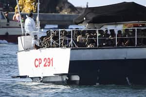 Migrantes dentro de un bote guardacostas en Lampedusa. La pequeña isla siciliana de Lampedusa está abrumada con casi 7000 migrantes llegados en las últimas 48 horas. La mayoría de los migrantes, principalmente de origen africano, partieron de Túnez.