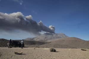 La gente observa una pila de humo y cenizas que se elevan desde el cráter del volcán Ubinas, ubicado en la región de Moquegua, en el sur de Perú, el 5 de julio de 2023.