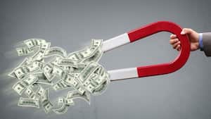Empresario atrayendo dinero con un concepto de imán de herradura para el éxito empresarial, la estrategia o la codicia