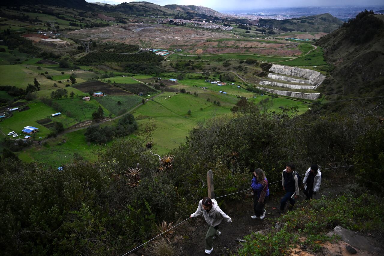 Los visitantes caminan por un sendero en el parque ecoambiental Mirachuelo cerca del vertedero de Doña Juana en Bogotá, el 10 de mayo de 2024.