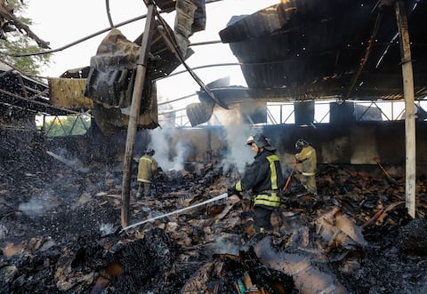 Los bomberos trabajan para extinguir el fuego en un almacén destruido por los bombardeos durante el conflicto entre Rusia y Ucrania en Donetsk, Ucrania controlada por Rusia