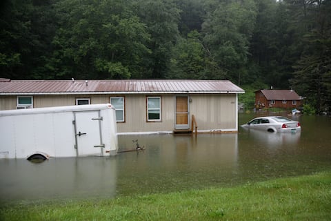 Las inundaciones suben en Bridgewater, Vt., el lunes 10 de julio de 2023, sumergiendo vehículos estacionados y amenazando casas cerca del río Ottauquechee.