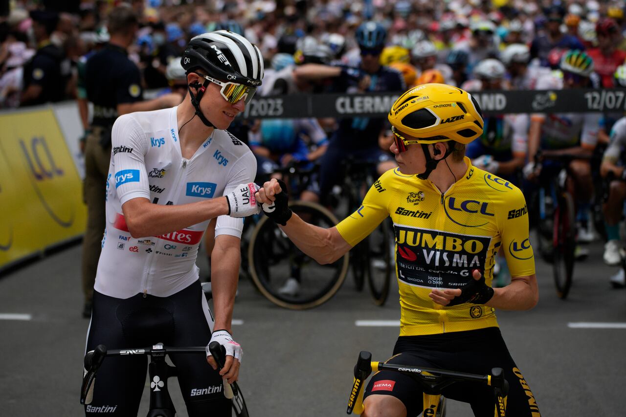 Slovenia's Tadej Pogacar, wearing the best young rider's white jersey, and Denmark's Jonas Vingegaard, wearing the overall leader's yellow jersey, pump fists prior to the eleventh stage of the Tour de France cycling race over 180 kilometers (112 miles) with start in Clermont-Ferrand and finish in Moulins, France, Wednesday, July 12, 2023. (AP Photo/Daniel Cole)