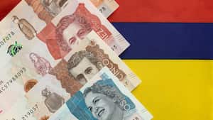 Dinero colombiano, billetes de pesos en el fondo de la bandera nacional de Colombia