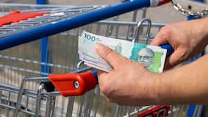 Carrito de compras en un supermercado y pesos colombianos, en mano, Concepto de inflación, Aumento de los costos de vida, Presupuesto doméstico