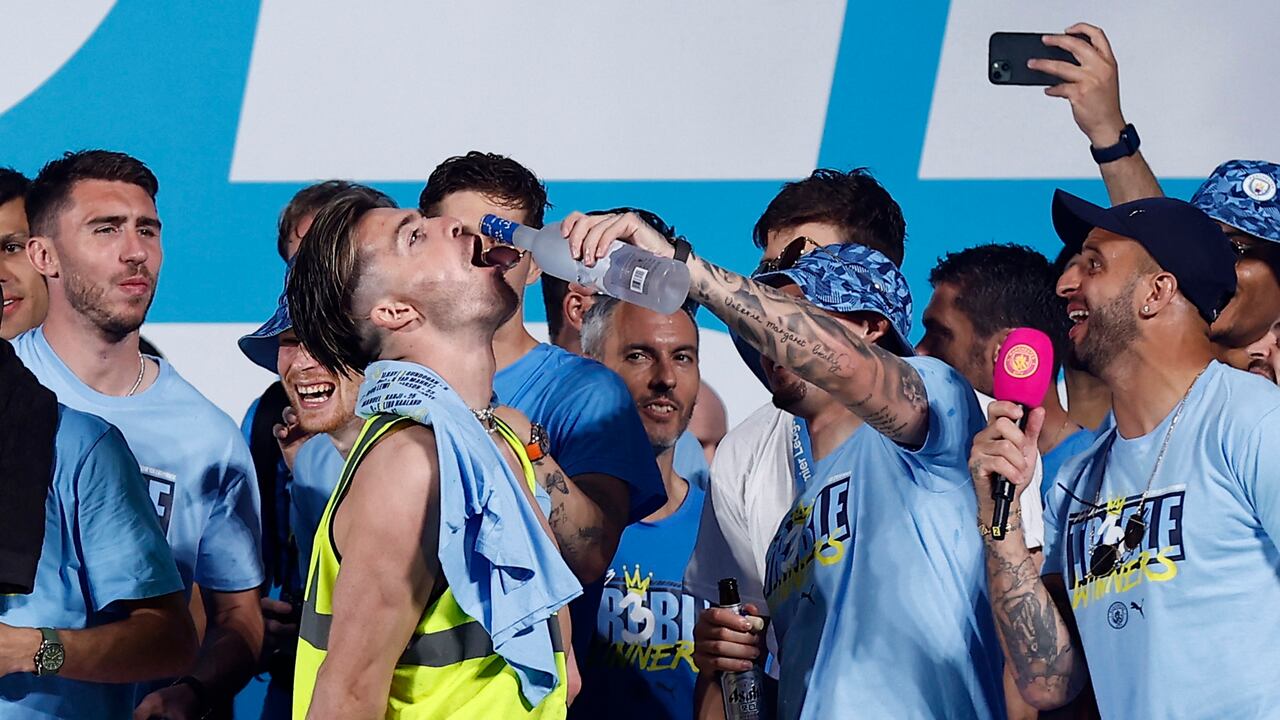 Soccer Football - Manchester City Victory Parade - Manchester, Britain - June 12, 2023 Manchester City's Jack Grealish has drink poured into his mouth on stage by Kalvin Phillips Action Images via Reuters/Jason Cairnduff