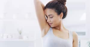 Cropped shot of a young woman smelling her armpits in the bathroom at home