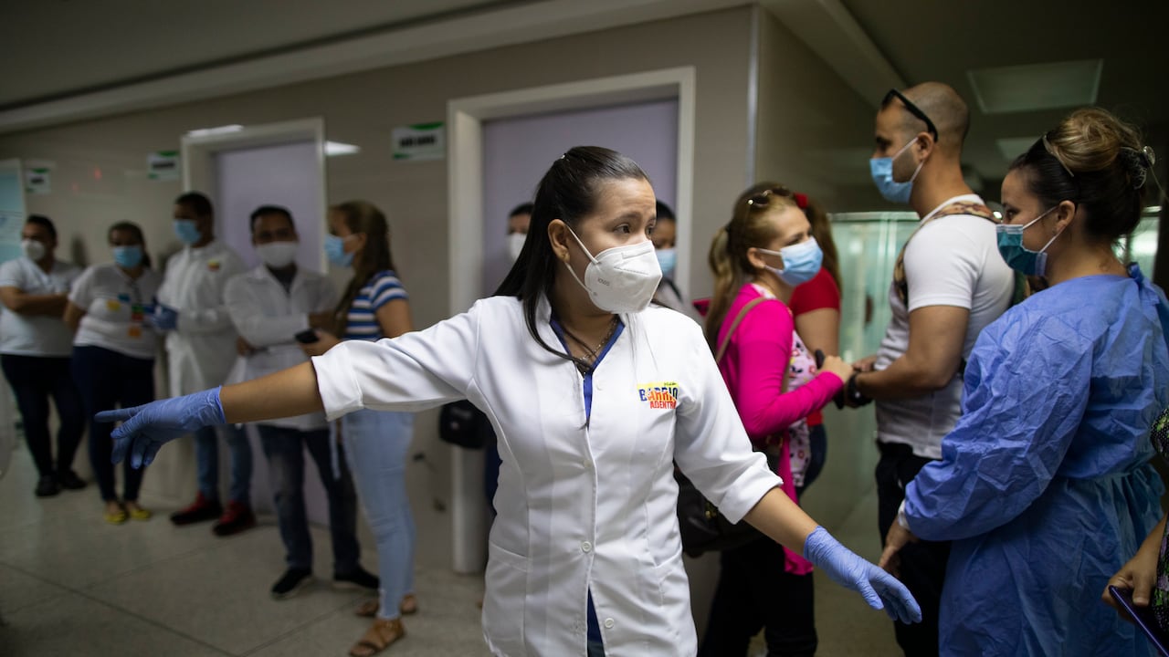 La jefa de enfermería Carla Rivero dirige a trabajadores de salud de Venezuela y Cuba, antes de que reciban una dosis de la vacuna Sinopharm COVID-19 en un centro de salud del programa de salud gubernamental Barrio Adentro, en Caracas, Venezuela. (Foto AP / Ariana Cubillos)