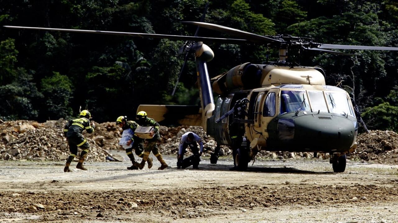 Members of the rescue team arrive at the zone of a landslide in the road between Quibdo and Medellin, Choco department, Colombia on January 13, 2024. At least 23 people were killed and around 20 are injured after a landslide in an indigenous community in northwestern Colombia, an official from the Choco department governor's office told AFP. (Photo by Fredy BUILES / AFP)