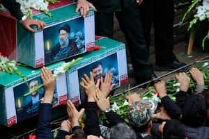 En esta fotografía proporcionada por la agencia de noticias Fars, los dolientes intentan tocar los ataúdes del presidente iraní, Ebrahim Raisi, arriba, el ministro de Asuntos Exteriores, Hossein Amirabdollahian, izquierda, y el jefe de los guardaespaldas de Raisi, el general Mehdi Mousavi, que murieron en un accidente de helicóptero el domingo en una región montañosa del noroeste del país, durante una ceremonia fúnebre en la ciudad de Tabriz, Irán, el martes 21 de mayo de 2024. (Ata Dadashi, Fars News Agency via AP)