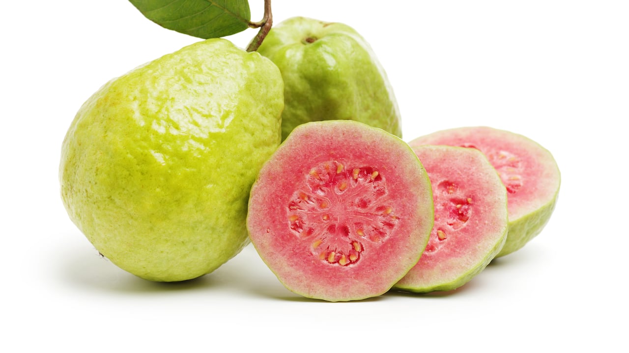 Fruta de la guayaba con hojas sobre fondo blanco