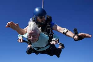 Esta foto proporcionada por Daniel Wilsey muestra a Dorothy Hoffner, de 104 años, cayendo por el aire con el saltador tándem Derek Baxter mientras se convierte en la persona de mayor edad del mundo en saltar en paracaídas, el domingo 1 de octubre de 2023, en Skydive Chicago en Ottawa, Illinois. Daniel Wilsey vía AP)