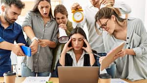 Grupo de trabajadores de negocios gritando a un socio estresado en la oficina.