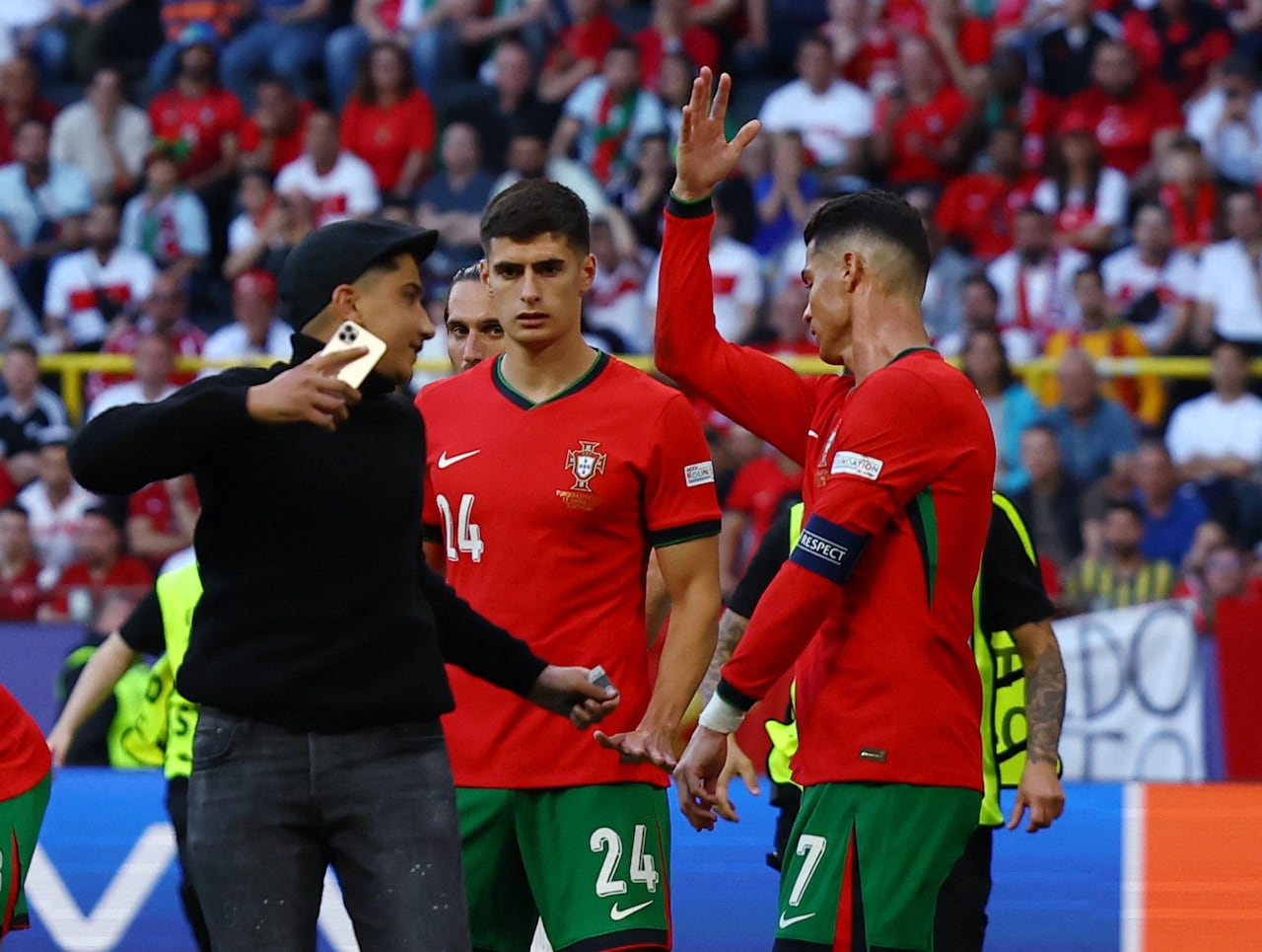 Soccer Football - Euro 2024 - Group F - Turkey v Portugal - Dortmund BVB Stadion, Dortmund, Germany - June 22, 2024 Portugal's Cristiano Ronaldo reacts as a pitch invader tries to take a picture REUTERS/Kacper Pempel