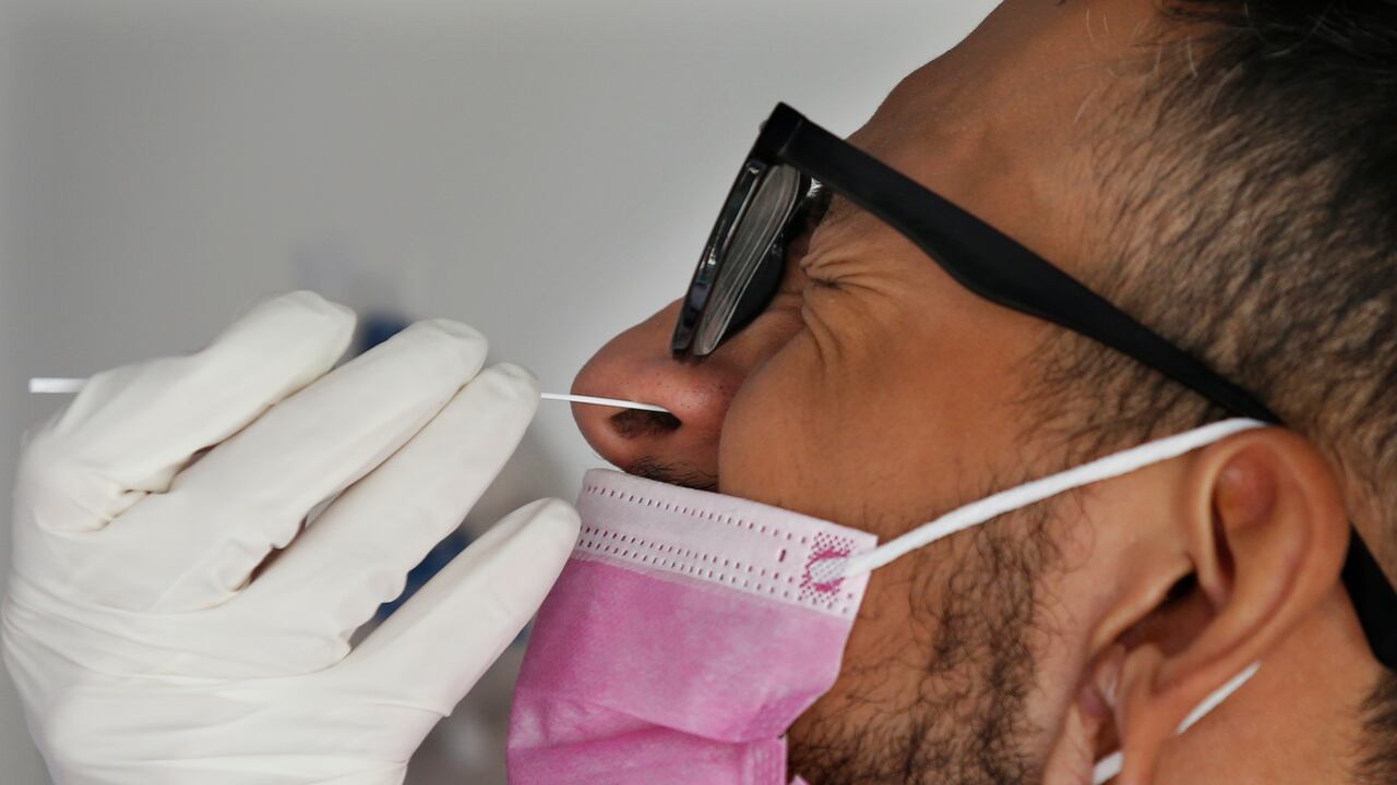 Un trabajador de salud recolecta una muestra de hisopado nasal para una prueba de COVID-19. (Foto AP / Marco Ugarte)