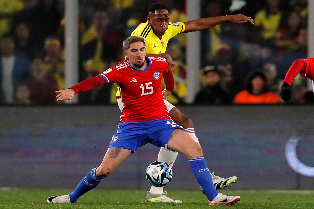 Chile's midfielder Diego Valdes (Front) fights for the ball with Colombia's defender Yerry Mina during the 2026 FIFA World Cup South American qualifiers football match between Chile and Colombia, at the David Arellano Monumental stadium, in Santiago, on September 12, 2023. (Photo by Javier TORRES / AFP)