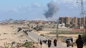 El humo se eleva tras un ataque israelí mientras los palestinos que huyen del norte de Gaza debido a la ofensiva militar de Israel se mueven hacia el sur, en medio del conflicto en curso entre Israel y Hamás, en el centro de la Franja de Gaza, el 15 de marzo de 2024.