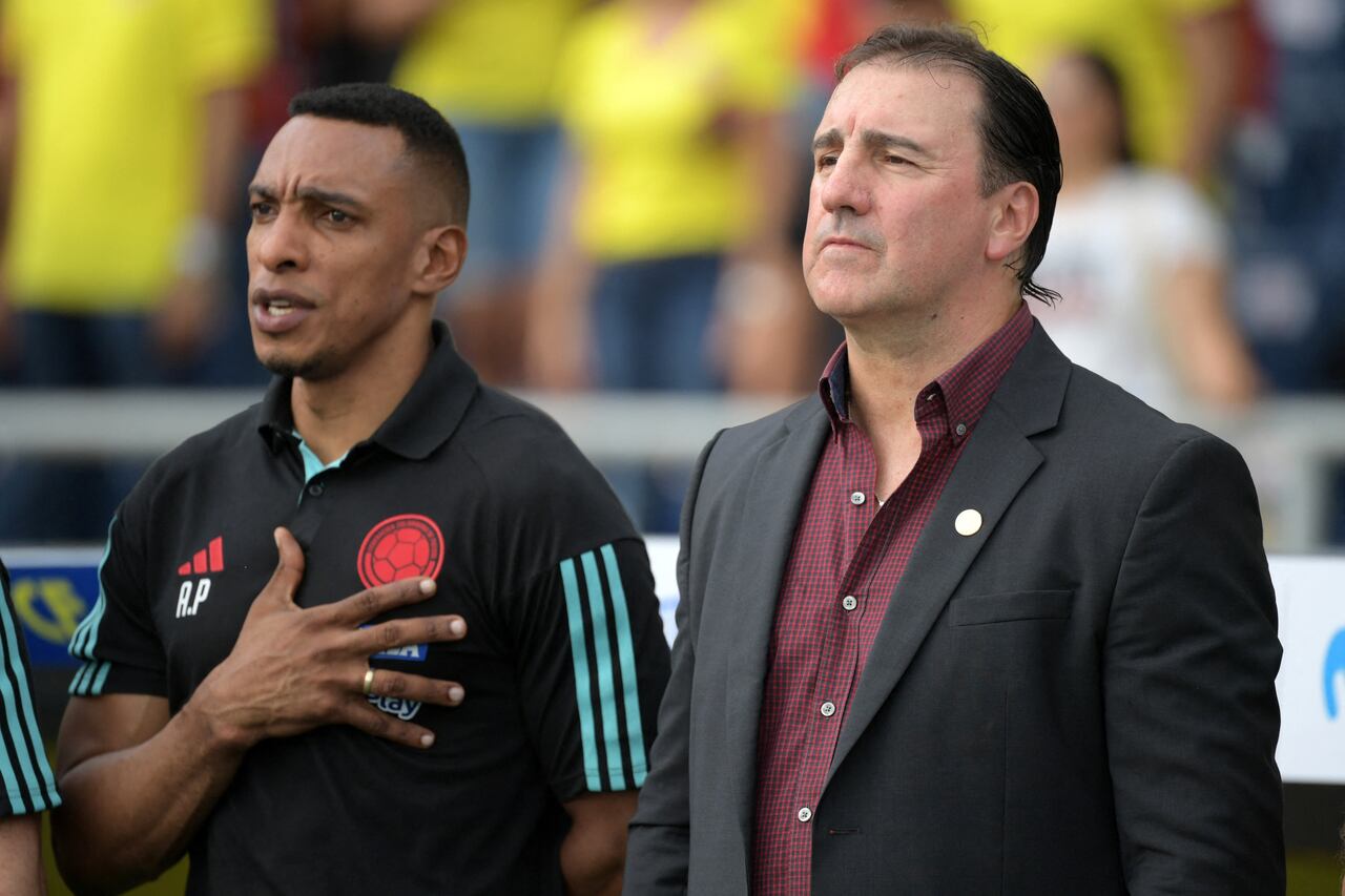 El entrenador argentino de Colombia, Néstor Lorenzo (R) y el entrenador asistente colombiano Luis Amaranto Perea escuchan los himnos antes del inicio del partido de fútbol de clasificación sudamericano para la Copa Mundial de la FIFA 2026 entre Colombia y Uruguay en el Estadio Metropolitano Roberto Meléndez en Barranquilla, Colombia, en octubre. 12 de diciembre de 2023. (Foto de Raúl ARBOLEDA / AFP)