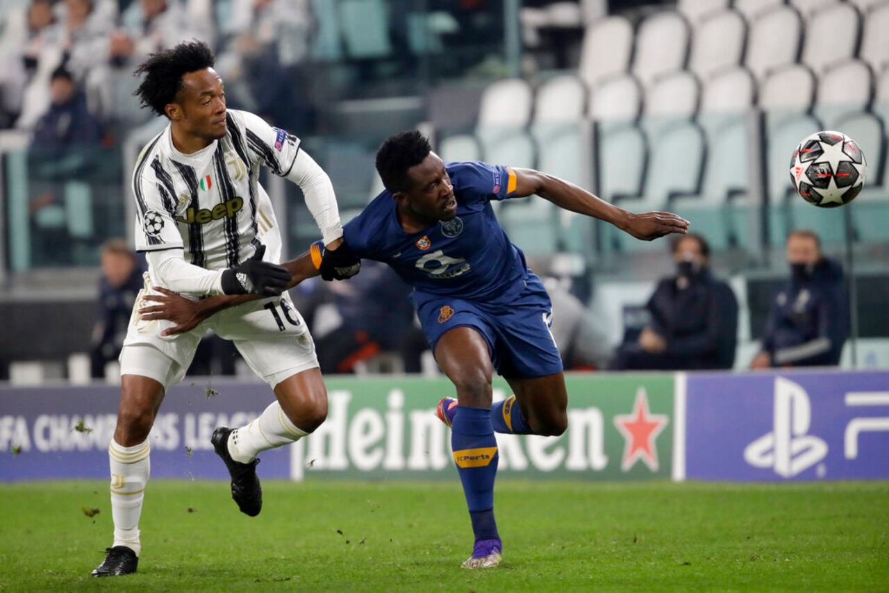 Juventus' Juan Cuadrado fights for the ball with Porto's Zaidu Sanusi, right, during the Champions League, round of 16, second leg, soccer match between Juventus and Porto in Turin, Italy, Tuesday, March 9, 2021. (AP Photo/Luca Bruno)