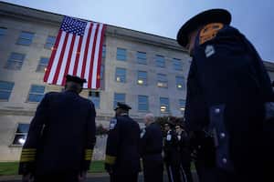 Los socorristas observan cómo se despliega una bandera estadounidense desde el techo del Pentágono para conmemorar el 22º aniversario de los ataques del 11 de septiembre de 2001, en el Pentágono en Washington, EE.UU., el 11 de septiembre de 2023. 