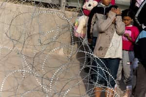 Una mujer reacciona mientras discute con un miembro de la Guardia Nacional de Texas mientras cruza el río Bravo, la frontera entre Estados Unidos y México, para solicitar asilo en El Paso, Texas, EE. UU., visto desde Ciudad Juárez, México 20 de diciembre de 2022. 