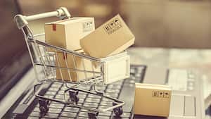 Cajas de papel en un carrito de compras en un teclado portátil. Ideas sobre comercio electrónico, comercio electrónico o comercio electrónico es una transacción de compra o venta de bienes o servicios en línea a través de Internet.