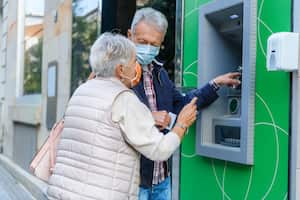 An Older Man and his Wife are Withdrawing Money From ATM Machine in the City During a Pandemic Time.