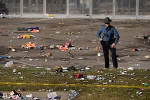 Un agente de la ley se encuentra entre los escombros mientras mira alrededor de la escena luego de un tiroteo en la celebración del Super Bowl de fútbol americano de la NFL de los Kansas City Chiefs en Kansas City, Missouri