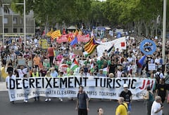 Los manifestantes sostienen carteles que dicen "Disminución del turismo" durante una protesta contra el turismo de masas en el callejón de Las Ramblas de Barcelona, ​​el 6 de julio de 2024.