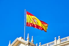 The Spanish flag flying on top of building roof, Spain.
