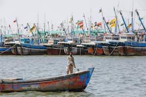 Un hombre navega en un bote, pasando junto a barcos de pesca anclados, después de que se impusiera una prohibición a las actividades costeras tras la tormenta ciclónica Biparjoy, sobre el Mar Arábigo, en el pueblo pesquero de Ibrahim Hyderi en las afueras de Karachi, Pakistán, el 12 de junio de 2023. 