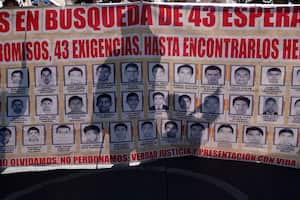 Familiares y simpatizantes de los 43 estudiantes de Ayotzinapa marchan con un gran cartel que muestra sus fotografías y nombres por el noveno aniversario de su desaparición, en Ciudad de México, el martes 26 de septiembre de 2023. (AP Foto/Marco Ugarte)
